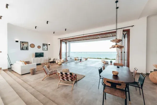 Modern open-concept living room with ocean view and large sliding doors.