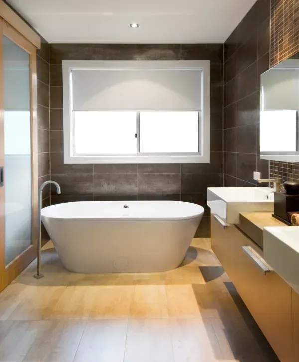 A modern bathroom interior featuring a sink, toilet, bidet, glass shower, and a heated towel rack.
