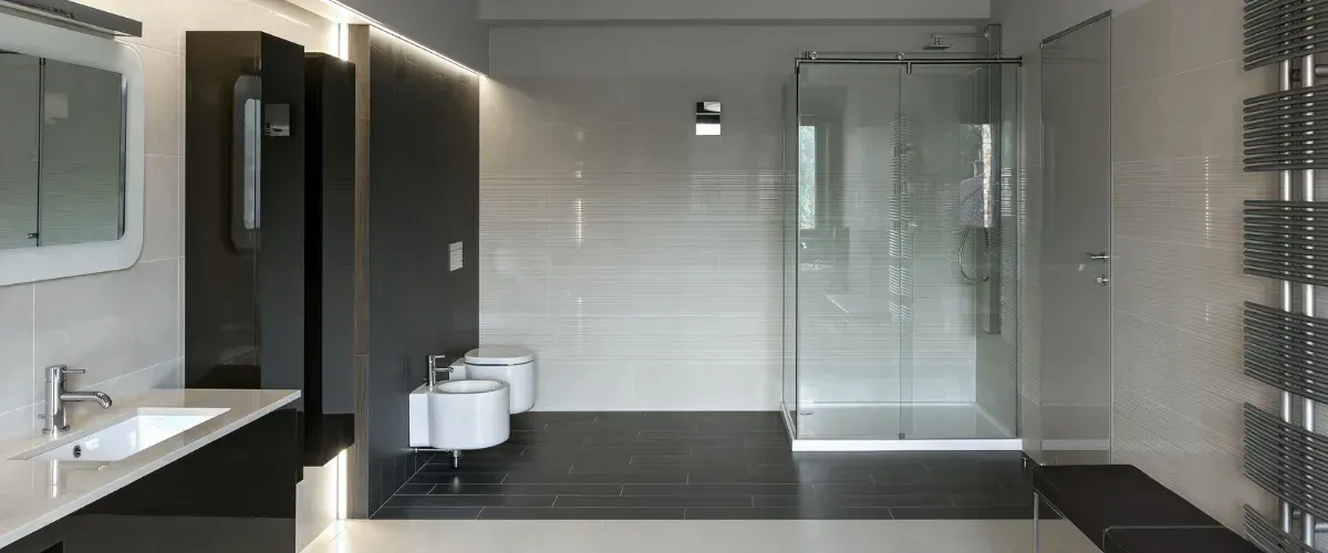 A clean, modern bathroom features a light wood double vanity with two white rectangular sinks and gray cabinets.