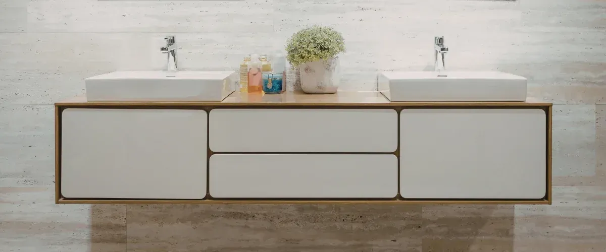 A modern bathroom vanity featuring two white vessel sinks, chrome faucets, and a dark countertop with light wood cabinets.