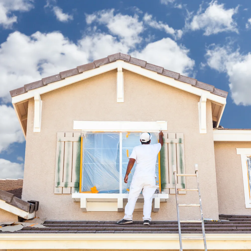 Picture of a worker painting the exterior of a house