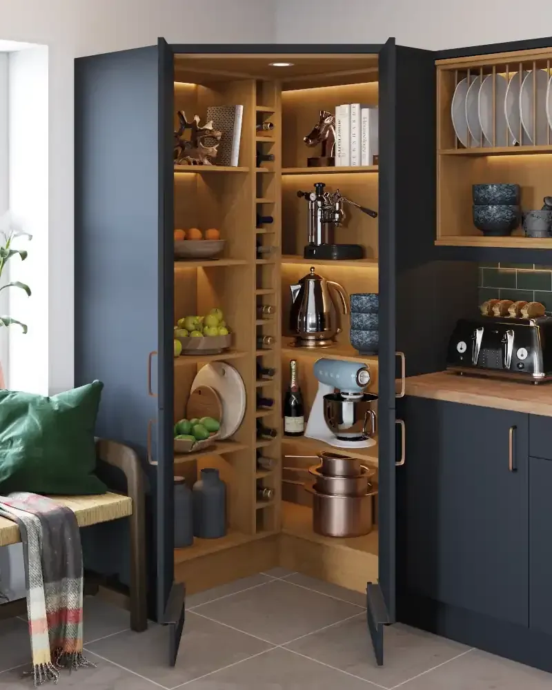 Bespoke kitchen pantry cupboard with navy blue exterior and natural wood interior, featuring integrated LED lighting, wine storage, appliance housing, and custom shelving solutions - Blueprint Kitchens Cornwall craftsmanship