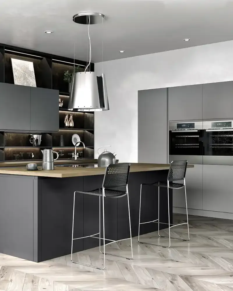 White handleless kitchen with black accent strips, corner window overlooking sea view, black tap, and wood flooring by Blueprint Kitchens