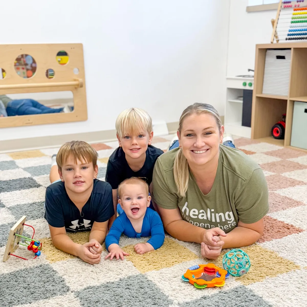 Mother holding a calm newborn in a bright, minimalist small-town clinic room
