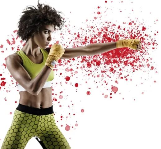 Smiling young woman holding large red boxing gloves up near her face, looking directly at the camera.