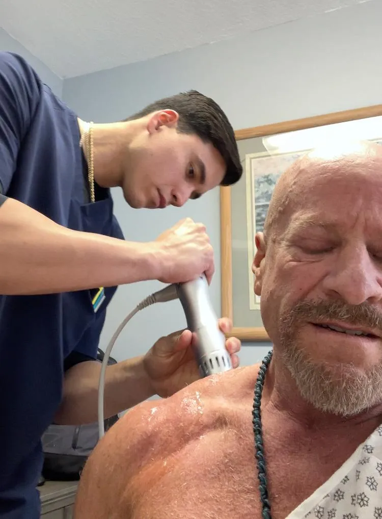 chiropractor using electrical stimulation on patient