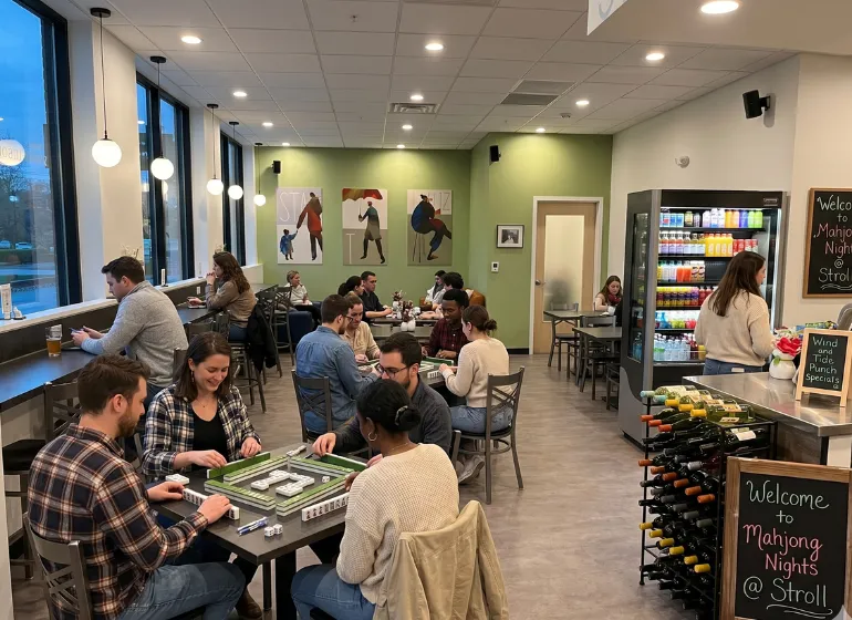 Group of people enjoying Mahjong Nights at Stroll Cafe, playing tabletop games in a bright, modern community coffee shop and bar setting.
