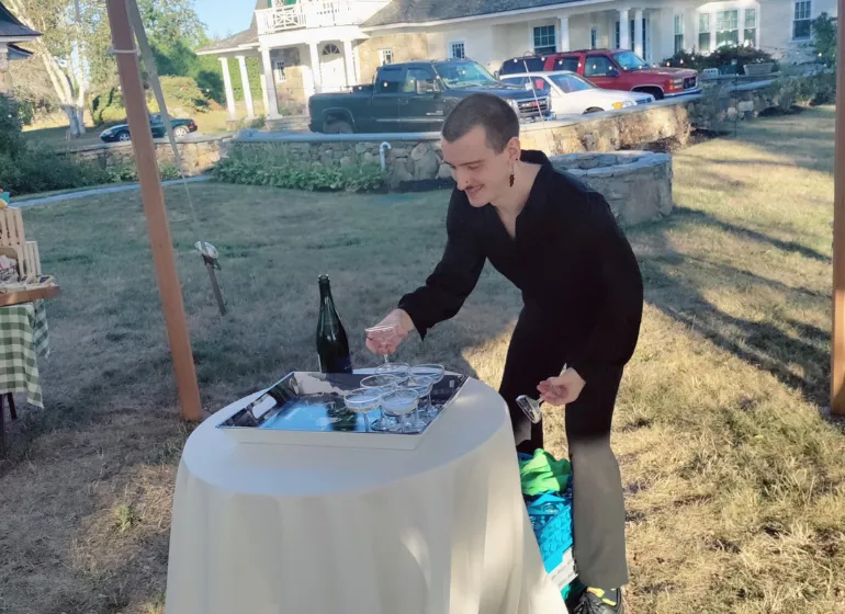 Stroll Cafe staff member setting up a beverage station for an outdoor event, representing our dynamic work environment, catering opportunities, and flexible schedule