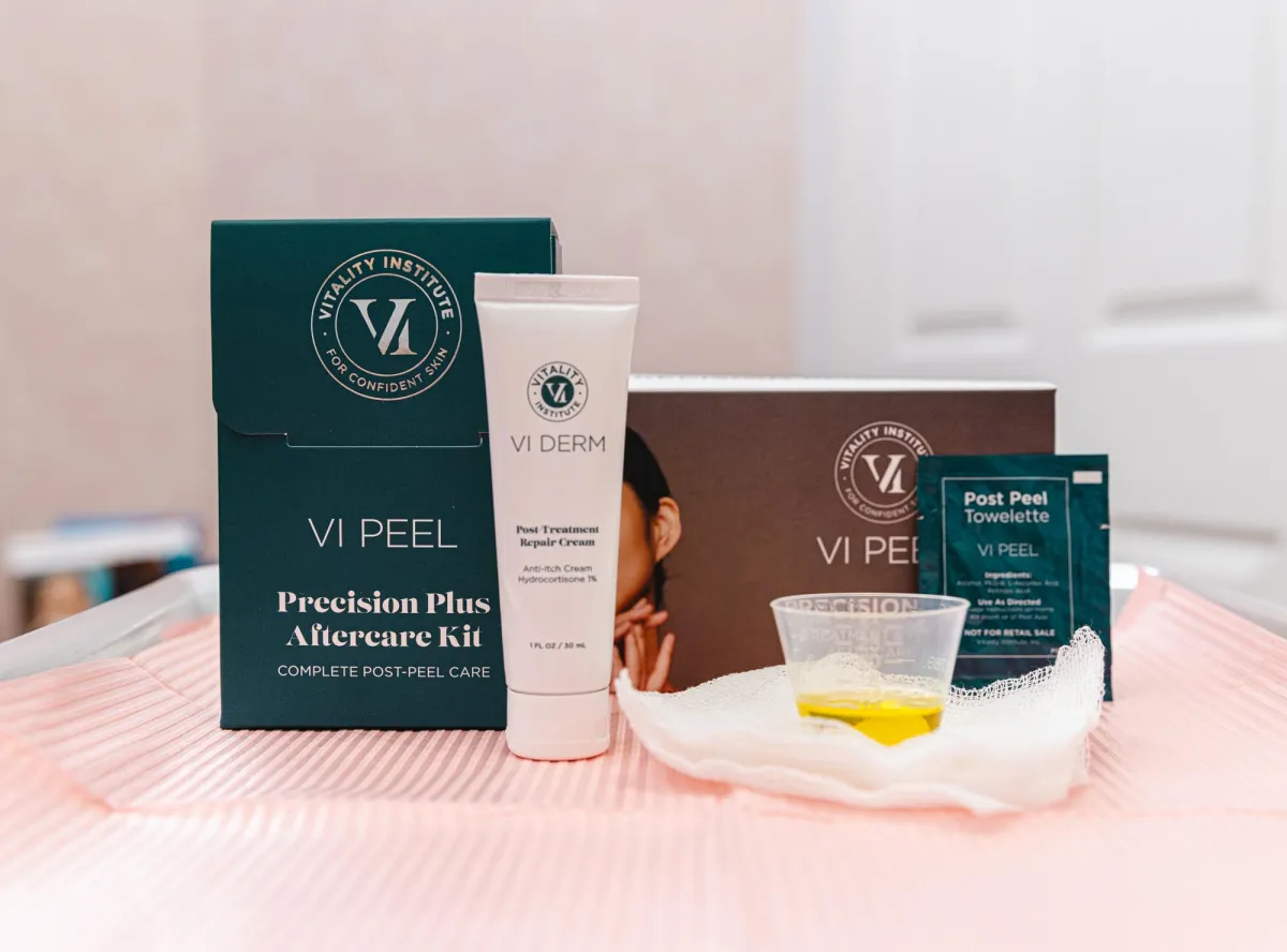 A white table topped with three bottles of makeup