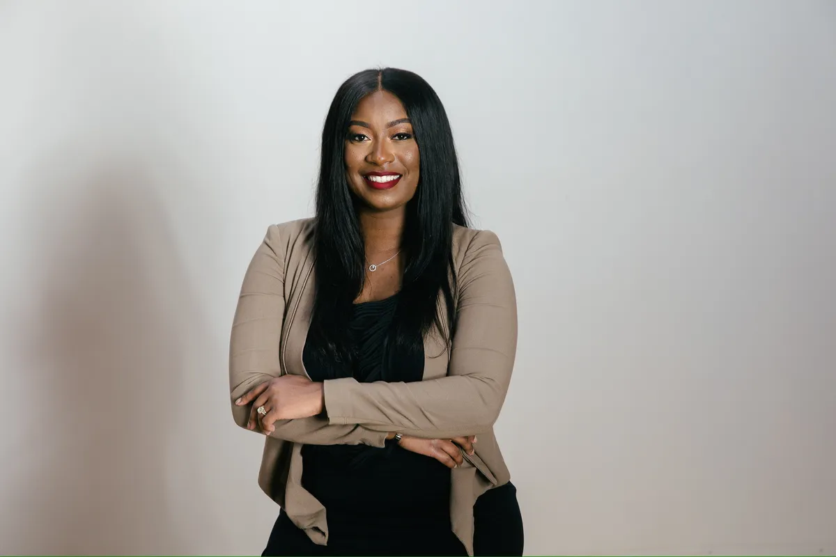 Dr. Sheneé Harris, DC smiling warmly in clinical attire