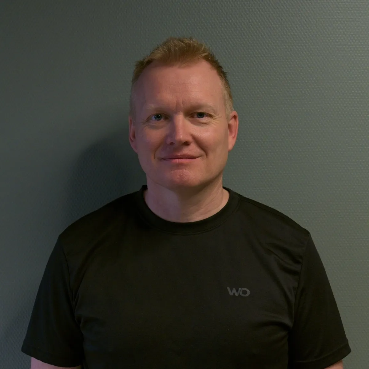 Portrait of Anna Berg, mid-40s, smiling professional in casual outdoor clothing, half-body against a neutral blurred background, natural lighting and approachable expression.