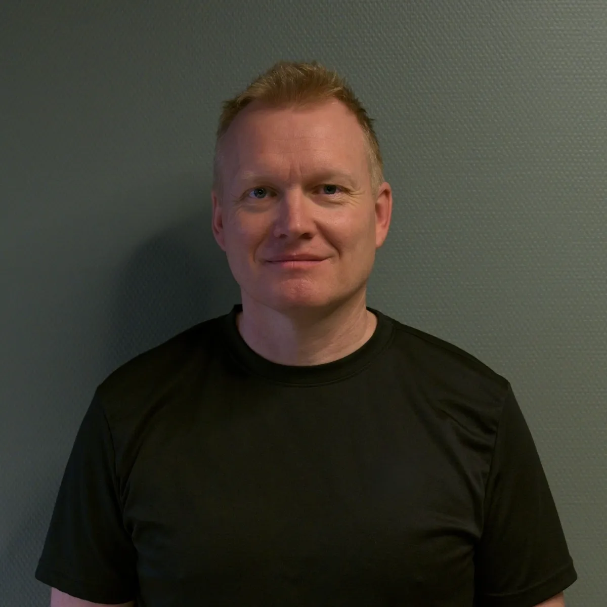 Portrait of Anna Berg, mid-40s, smiling professional in casual outdoor clothing, half-body against a neutral blurred background, natural lighting and approachable expression.
