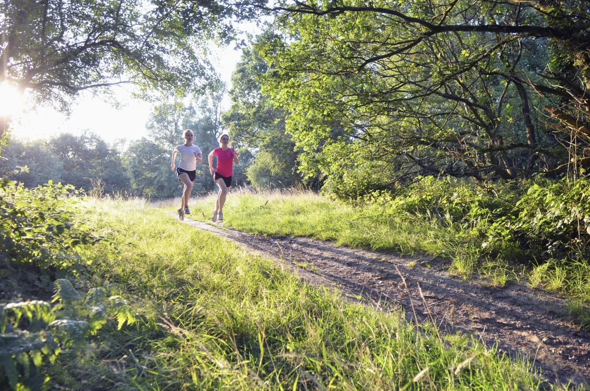 Two young women running in the countryside