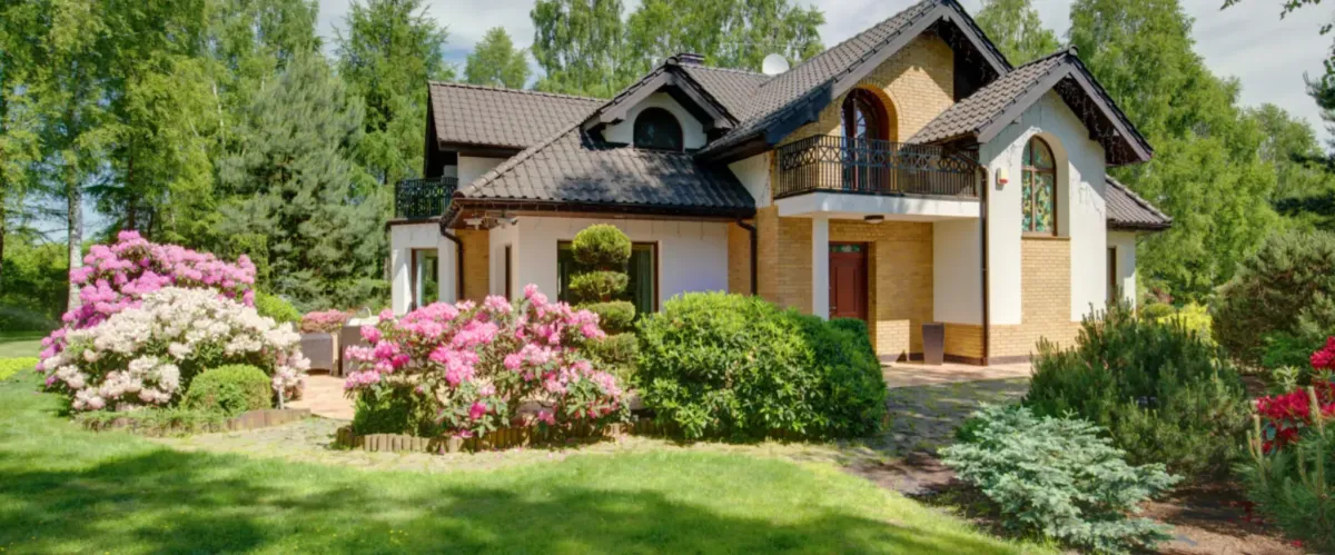 Colorful spring garden with blooming flowers and green lawn.