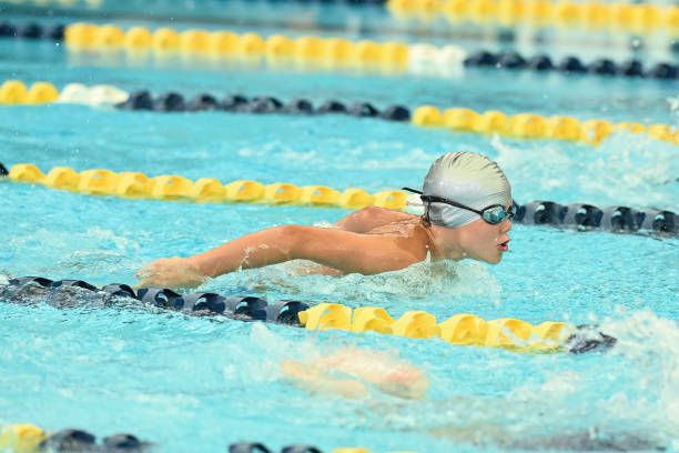 Young male competitive swimmer racing freestyle during an elite swimming event