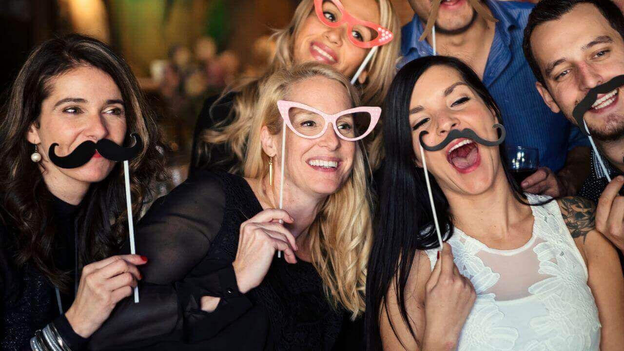 A group of people are posing for a picture with fake mustaches and glasses.