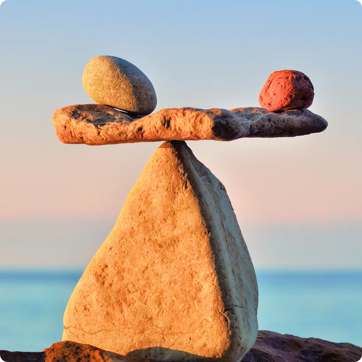 Balanced stones on beach representing whole-body wellness