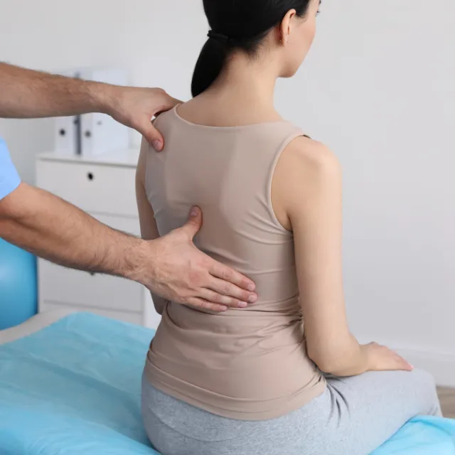 Chiropractor performing spinal and musculoskeletal evaluation on patient