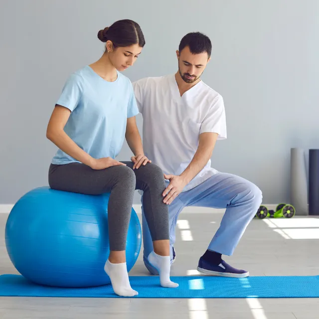 Plano Chiropractor advising patient on posture with exercise ball