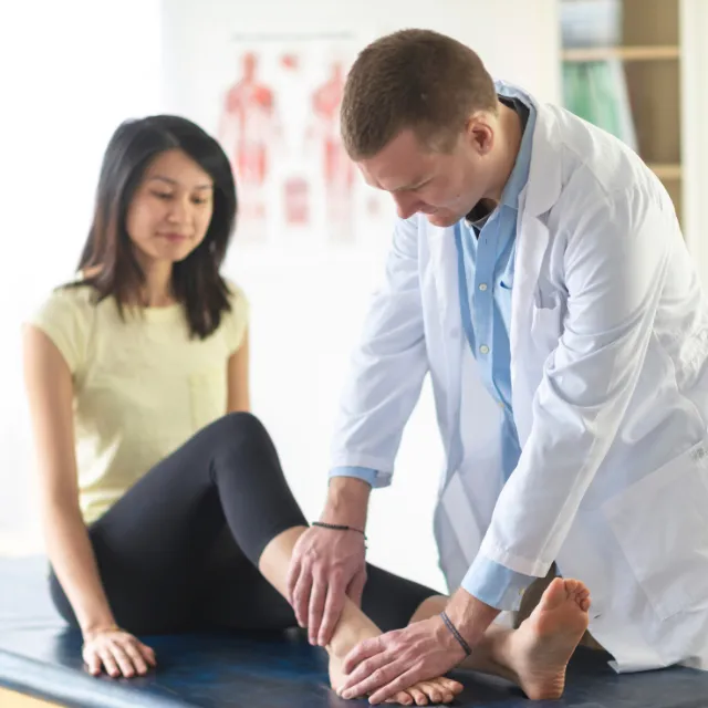 Therapist treating ankle sprain on patient