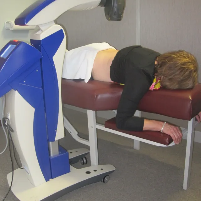 Plano chiropractor applying MLS® laser to patient’s knee for anti-inflammatory treatment