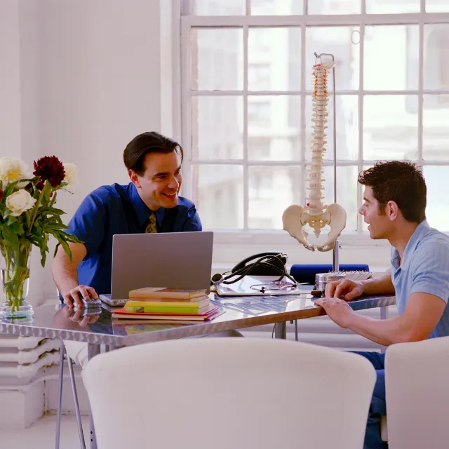 Plano chiropractor consulting with patient about evaluation findings
