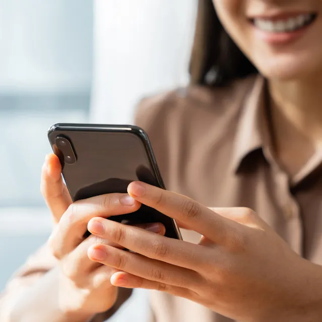 Person holding a mobile phone to contact Martin Chiropractic Clinic in Plano