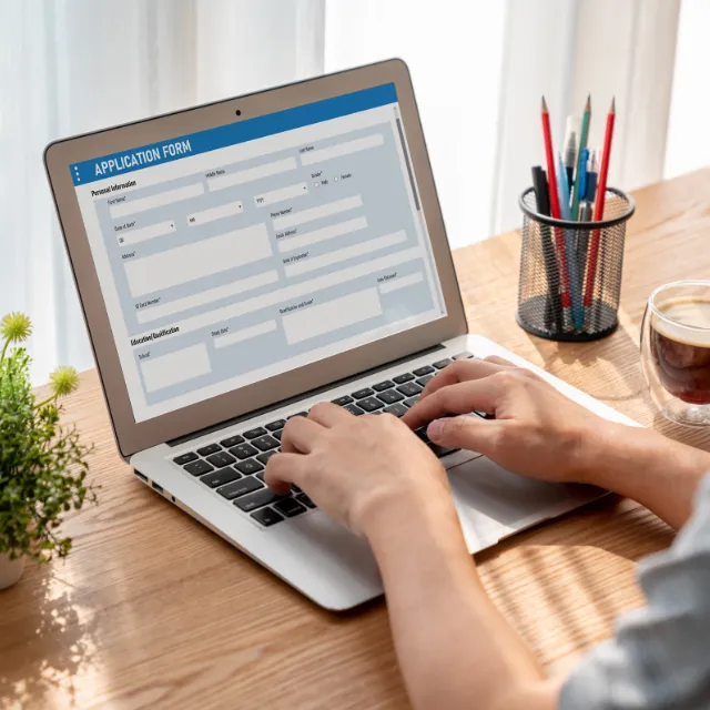 Hands completing the online appointment form for Plano Chiropractic Clinic