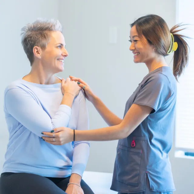 Plano chiropractor providing compassionate care and guiding a patient’s arm stretch
