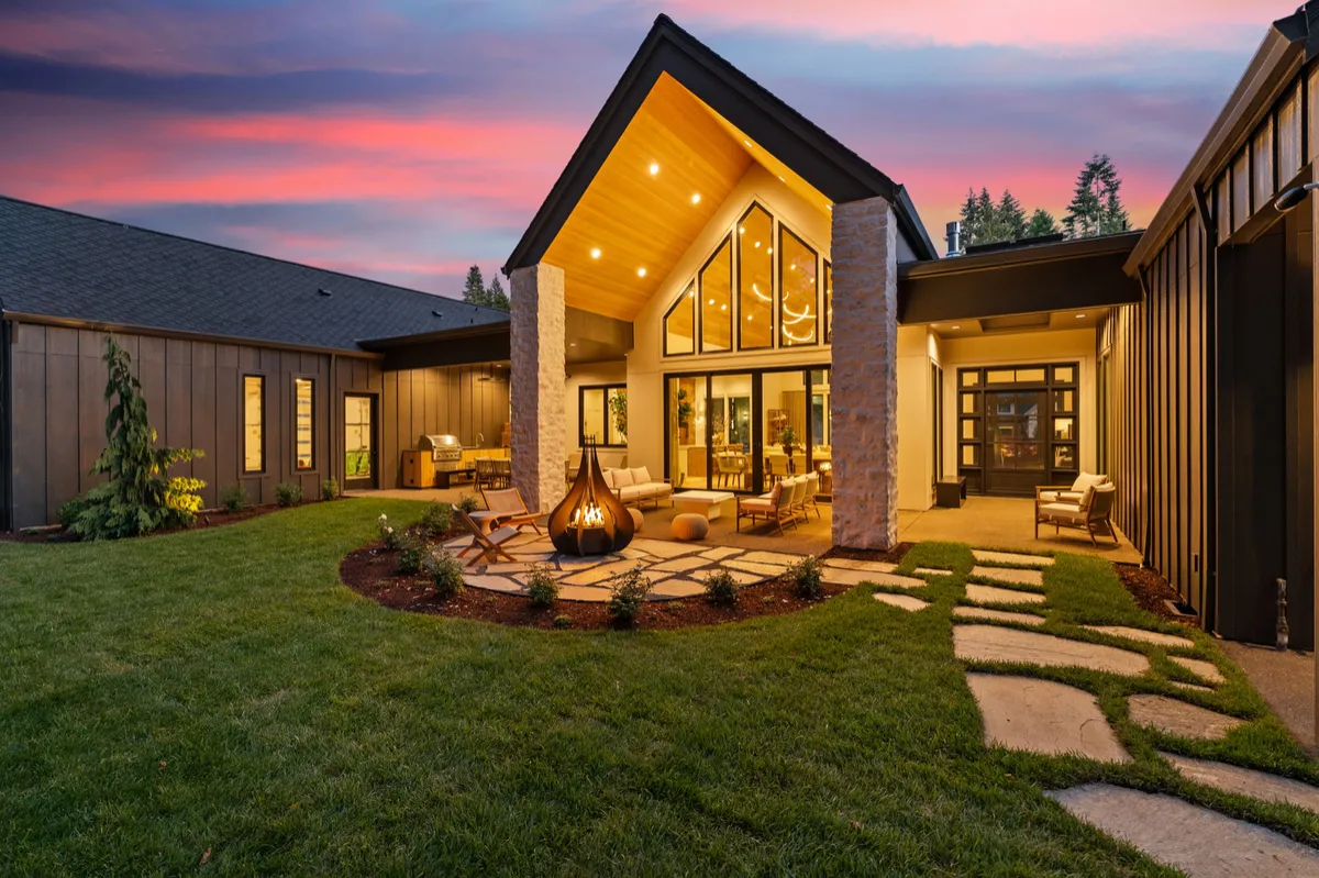 Illuminated modern home and landscaped courtyard at twilight