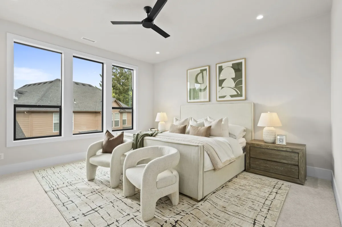 Neutral bedroom with large windows and seating