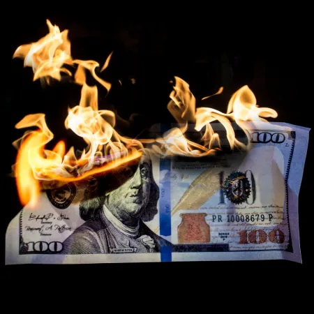 A one hundred dollar bill erupts into flames