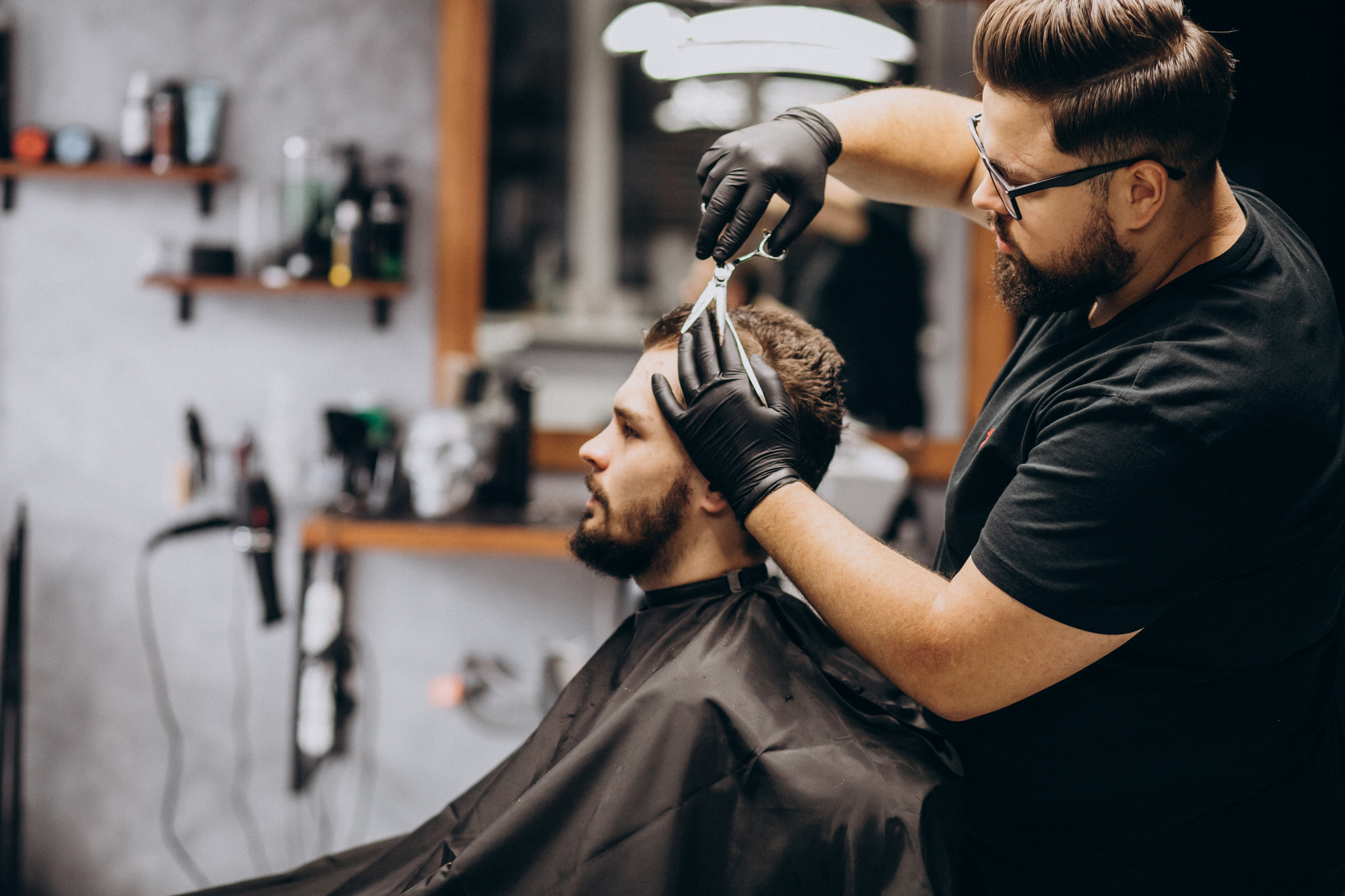 Barber cutting a male client's hair in a professional barbershop — representing grooming and personal care small business owners who qualify for Bayside Business Advisors funding solutions in Miami.
