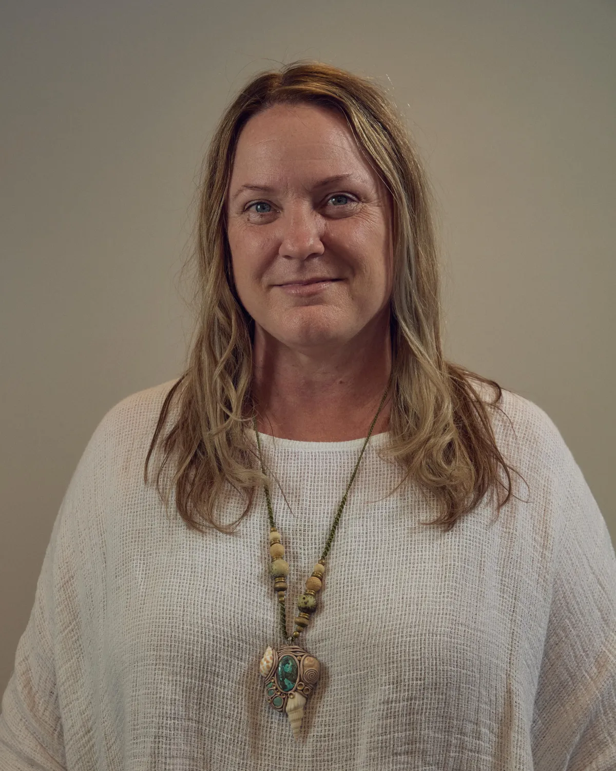 black and white pacific islander man standing in front of a rock wall