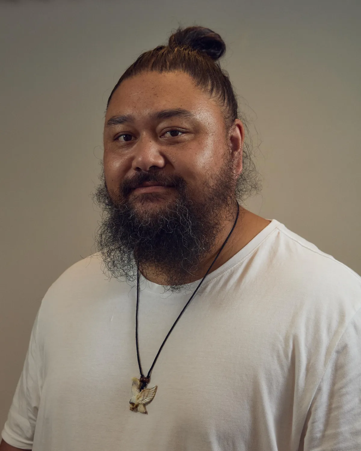 black and white pacific islander man standing in front of a rock wall