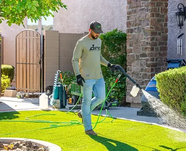 Landscaper cleaning and maintaining artificial turf for a fresh, well-kept lawn