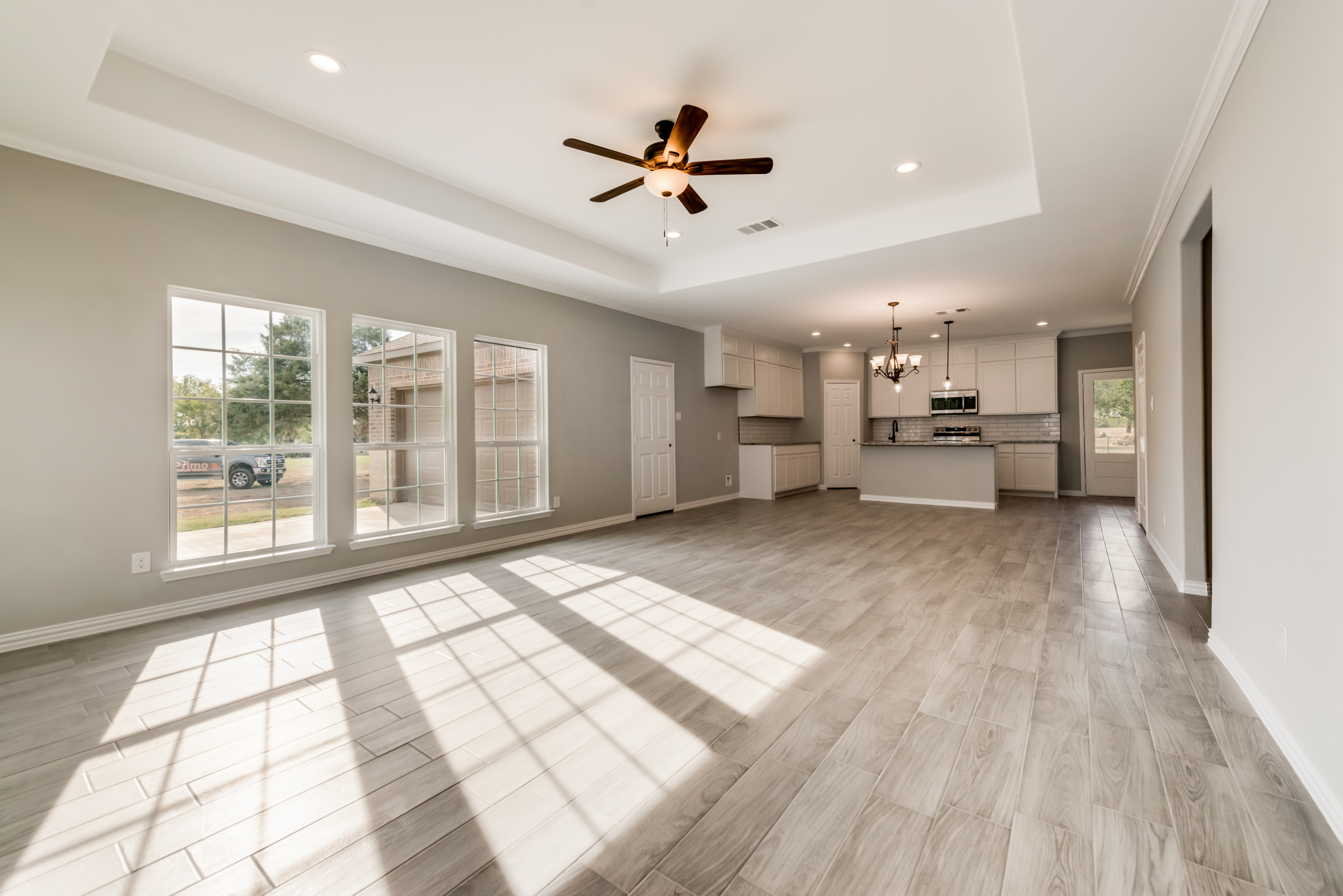Warm ranch-style living room with stone fireplace by Texas Prime