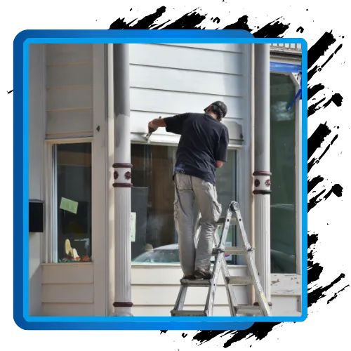 Exterior painting contractor on ladder painting residential building, enhancing curb appeal.