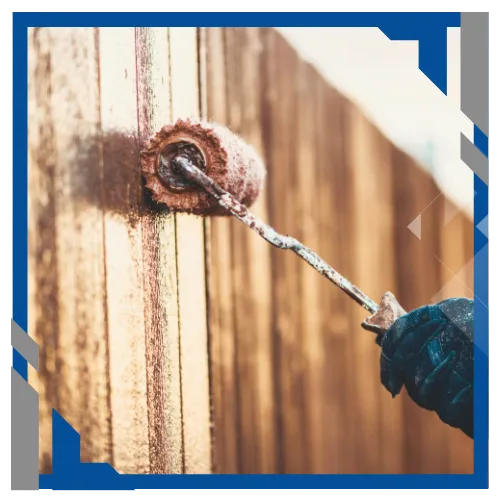 Fence painting in progress with roller and textured wood surface