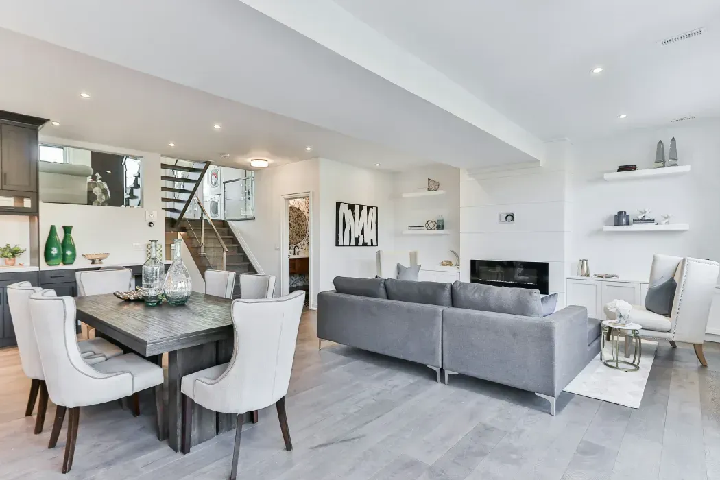 Spacious and modern living room with an open-concept design, elegant furniture, and natural light.