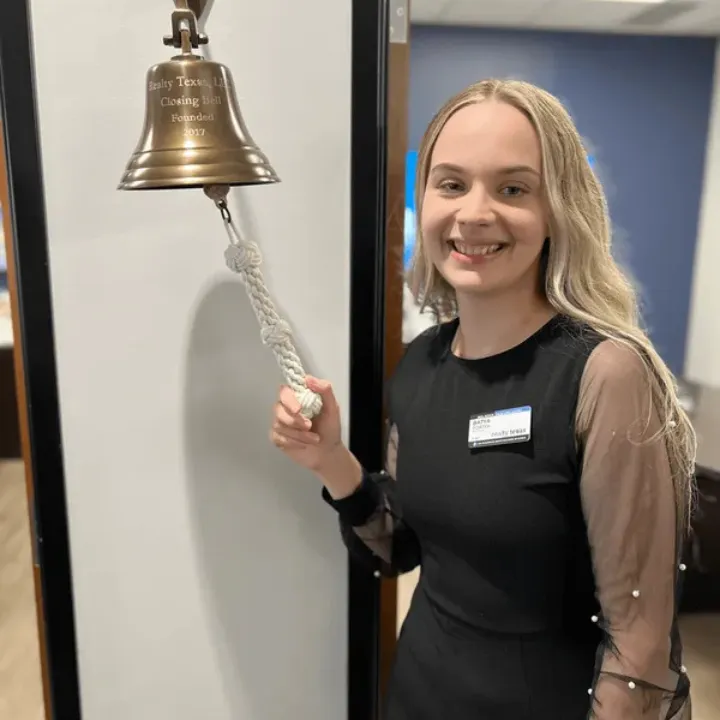 Batya Porter celebrating a successful real estate closing by ringing the closing bell.