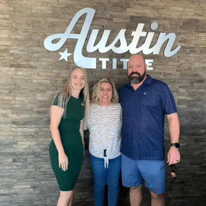 Batya Porter celebrating a successful real estate closing with happy clients at Austin Title.