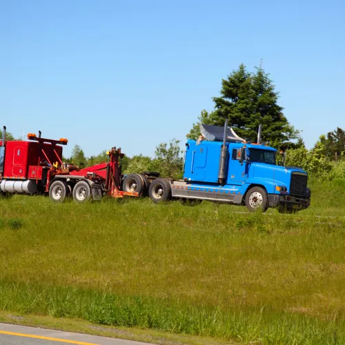 grey car being towed by a tow truck