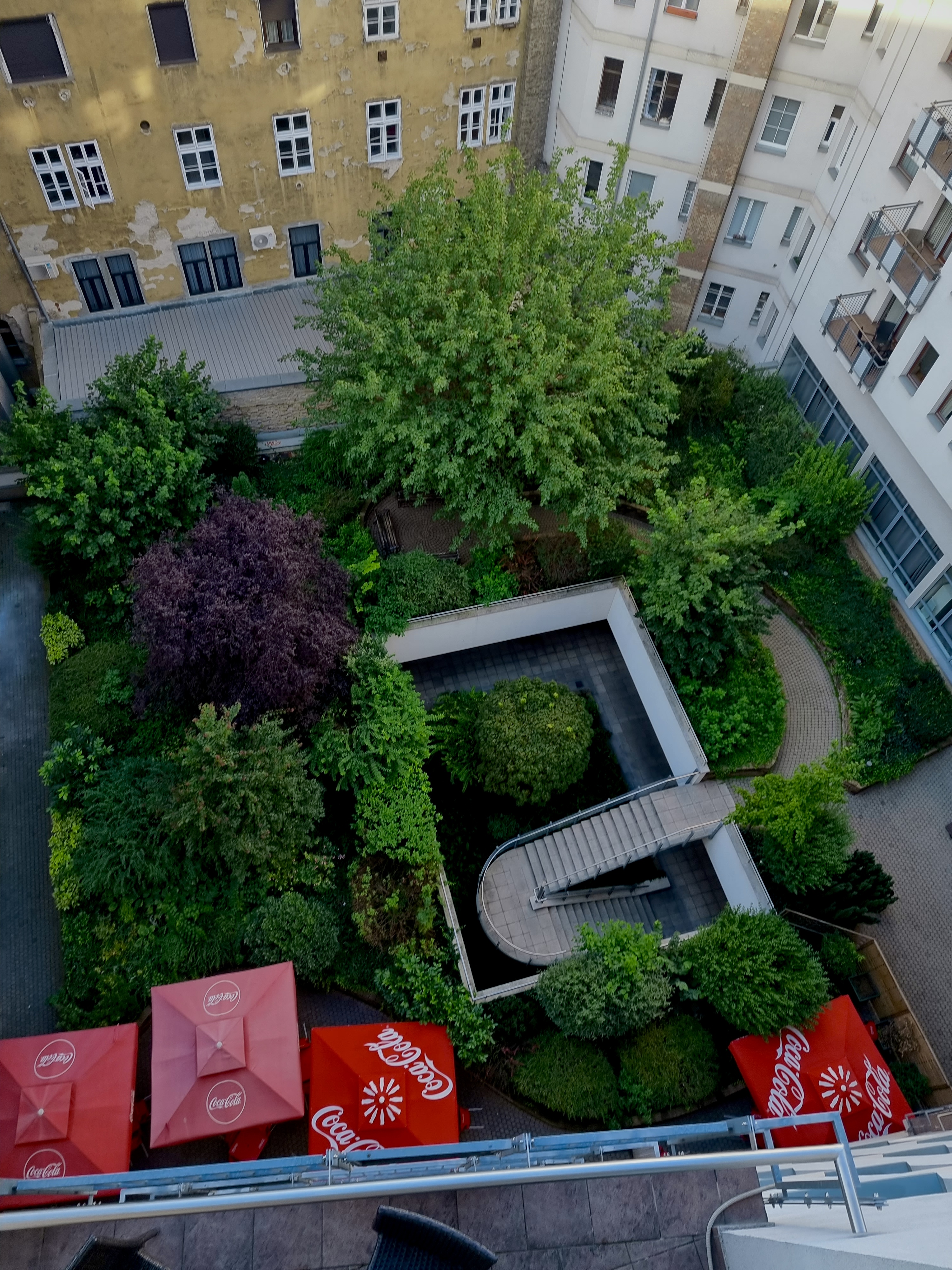 Társasházi belső udvar kertkarbantartással, gondozott növényzettel és zöldfelületekkel