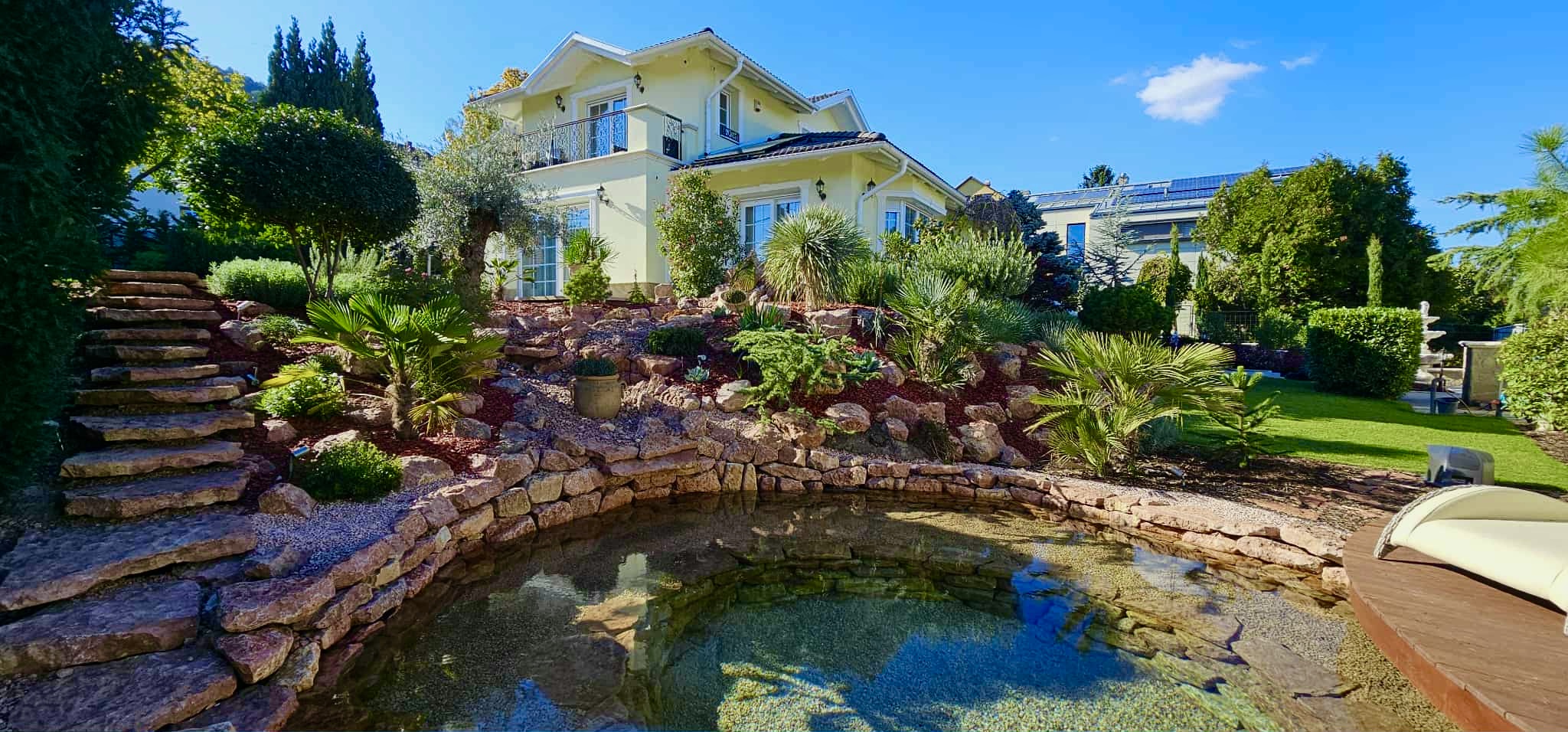 Sziklakertes kertépítés ültetett cserjékkel és dísznövényekkel, esztétikus kialakítással