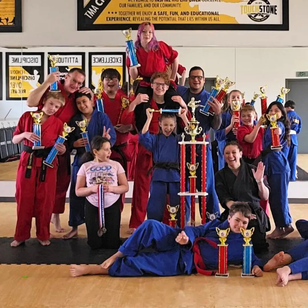group of children and teens having fun at a martial arts school