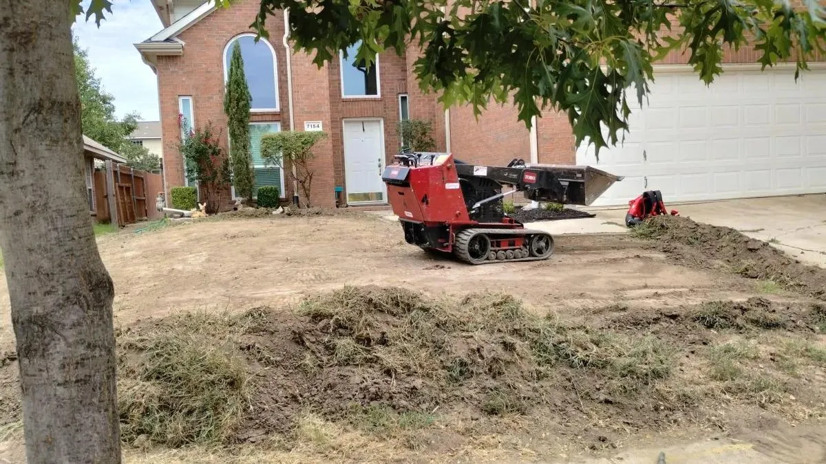 Bobcat machine clearing overgrown brush from a front yard in Lewisville, TX