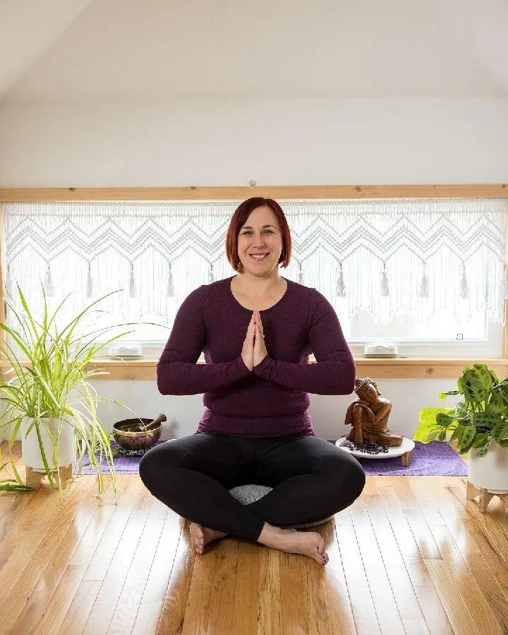 Ashley seated with hands in prayer position. 