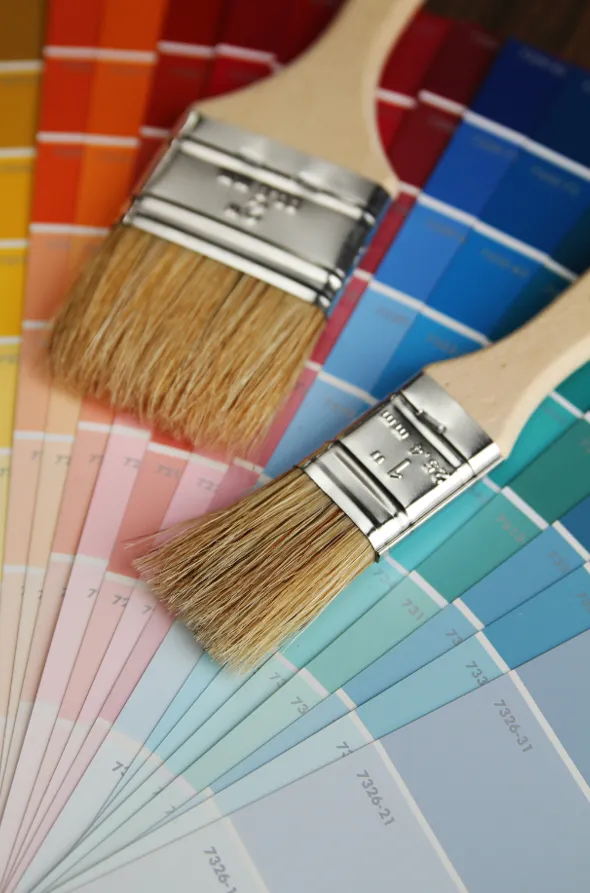 Two brushes with a wooden handle on top of a color guide
