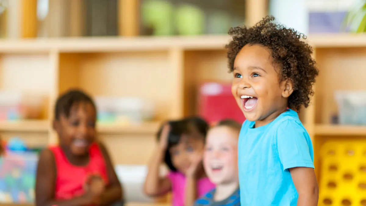 Kids moving with the teacher on a large screen TV